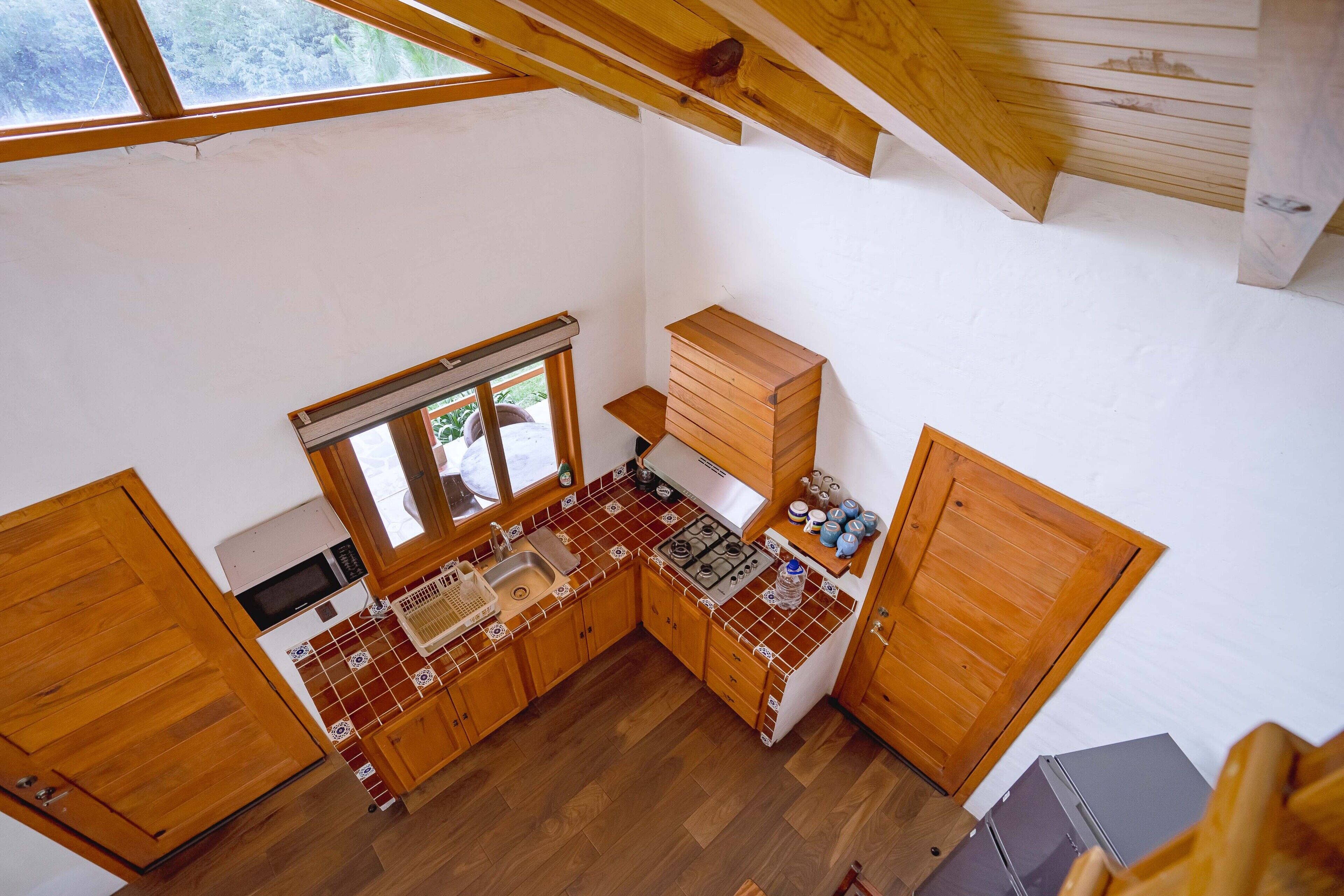 Una cocina compacta con muebles de madera, estufa y lavamanos.