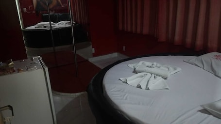 A hotel room with a bed, a mirror, a dresser, and a red carpet.. HOTEL TRÊS ESTRELAS
