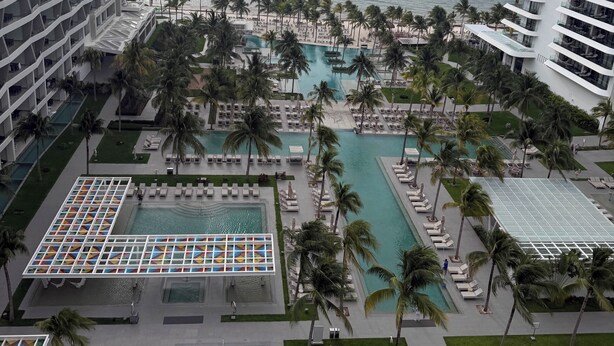 A resort with multiple swimming pools, palm trees, and a view of the ocean. - Garza Blanca Resort: Spacious 1,830 sq ft 2-bedroom suite for up to 6 guests. (Cancún)