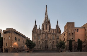A historic cathedral with a tall spire, large arched windows, and a symmetrical facade. - Central House 1 BR Appartment (Barcelona)