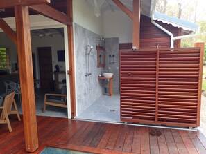 A wooden deck leading to a bathroom with a shower, sink, and a towel rack. - Lodge beautiful nature 1,private pool, large garden.900m from the beach of grande anse (Deshaies)