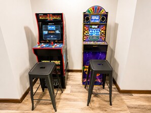 Two arcade machines, one for Mortal Kombat and one for Wheel of Fortune, with stools in front. - 1 block Lambeau, sleeps 14+, private yard, patio, heated tailgate garage, arcade (Green Bay)