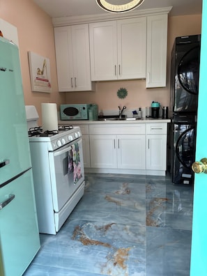 A kitchen with white cabinets, a stove, a microwave, and a Samsung refrigerator.