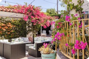 An outdoor seating area with wicker furniture and a metal fence.