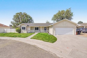 A single-story house with a front garage, a covered porch, and a well-maintained lawn.