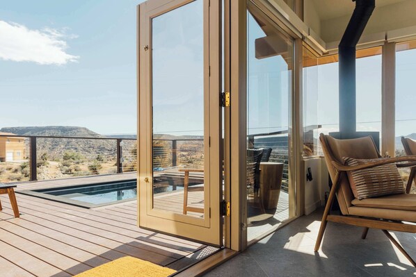 Eine Poolterrasse mit Liegestuhl und Tisch.