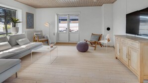 A modern living room with a sofa, coffee table, and a television. - "Senija" - 175m from the sea by Interhome (Blokhus)