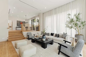 Ein modernes Wohnzimmer mit einer Couch, einem Couchtisch und einer Sitzecke.
