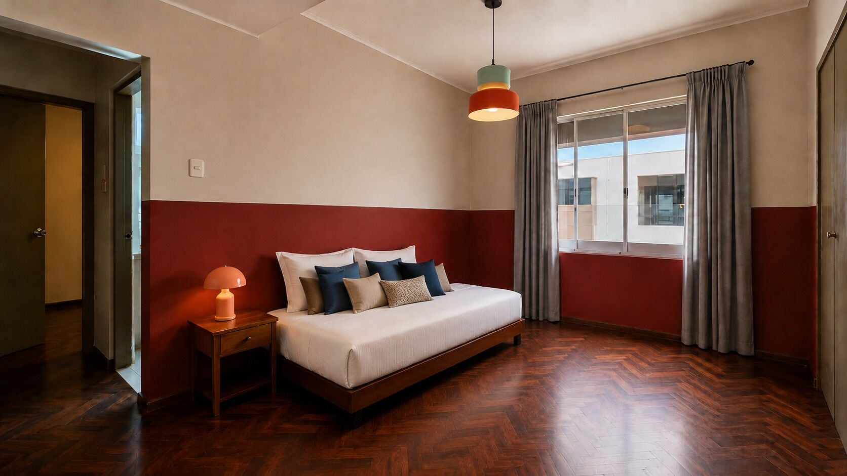 A bedroom with a bed, bedside table, lamp, and a view of the outside through a window.