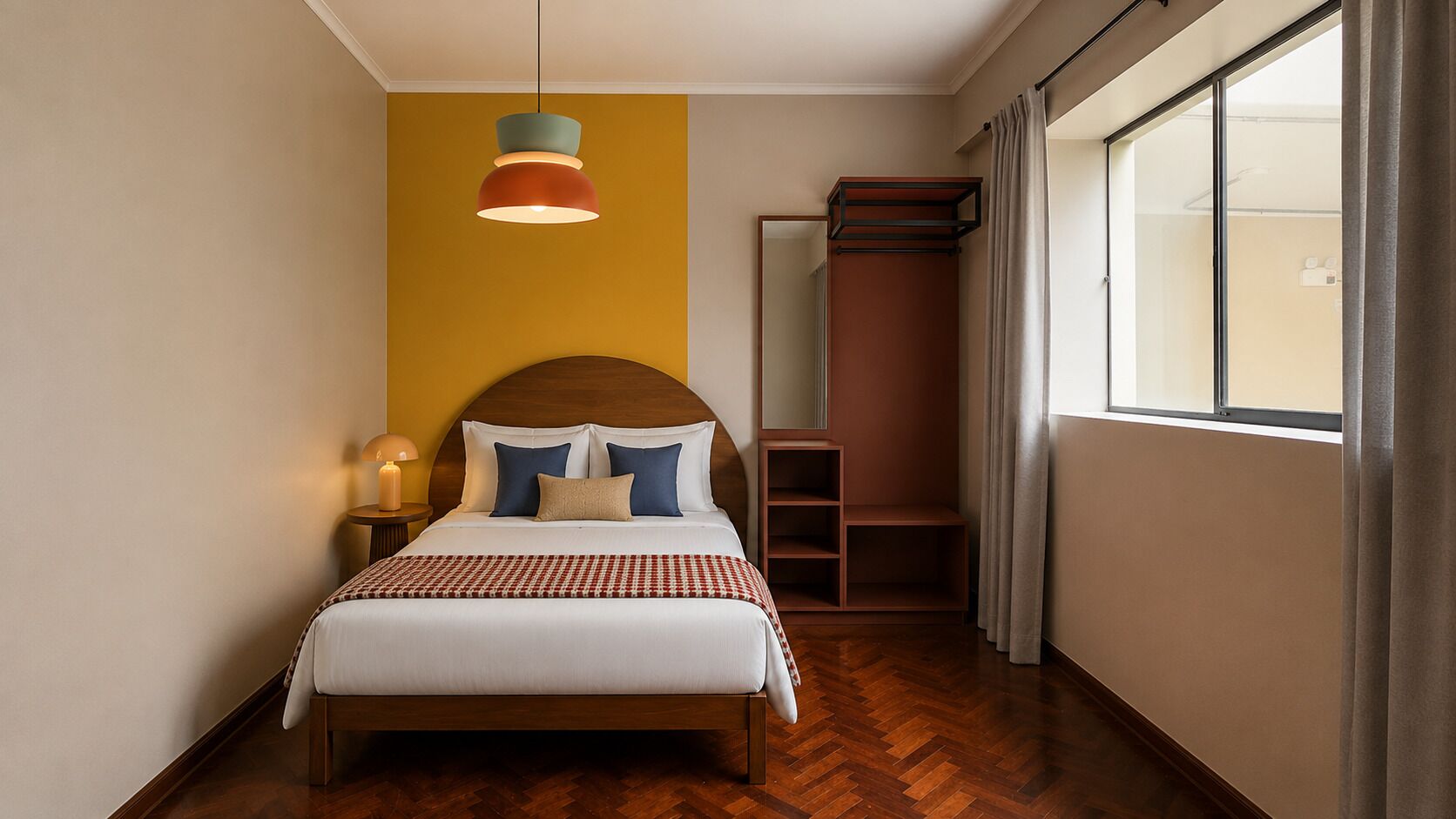 A hotel room with a bed, bedside lamp, a hanging pendant light, a wardrobe, and a window with curtains.