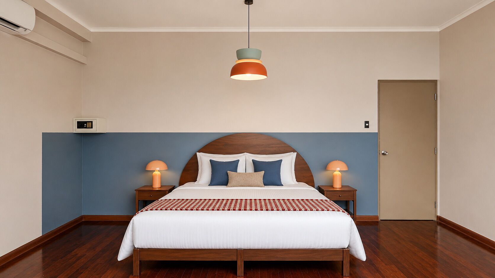 A bedroom with a wooden bed, two bedside lamps, a ceiling light, and a door.