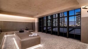 Ein modernes Hotelzimmer mit großem Fenster, einer Rezeption und Blick auf die Stadt.