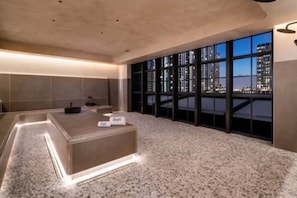 A modern hotel room with a large window, a reception desk, and a city view. - The Brickell Estates (Miami)