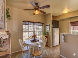 A kitchen with a dining table, chairs, a ceiling fan, a refrigerator, and a window with a view of the street. - Union Street Townhouse 2BD/1.5BA Near Whiskey Row (Prescott)