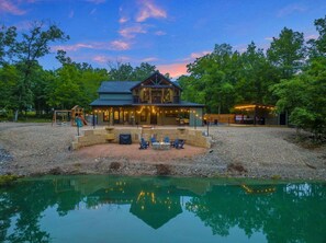 A two-story house with a patio, a swimming pool, and a deck with outdoor seating.