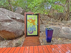 A pathway leading to a door with a mosaic of a mythical creature. - Alma Rocks (Arcadia)