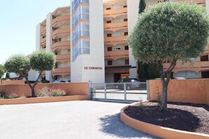 A multi-story building with balconies, a gated entrance, and a sign that reads 'LE CANASTEL.' - 2 rooms sea view Boucanet parking beaches 200m away (LE GRAU DU ROI)