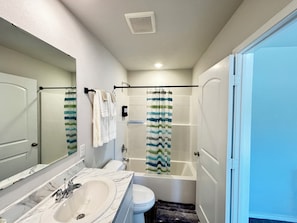 Une salle de bain Ă©quipĂ©e dâun lavabo, de toilettes, dâune baignoire et dâun rideau de douche.