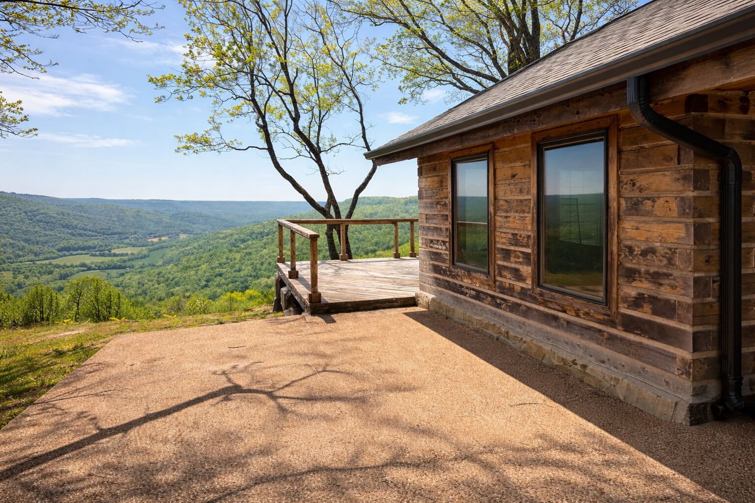 Uma cabana com varanda com vista para um vale arborizado.