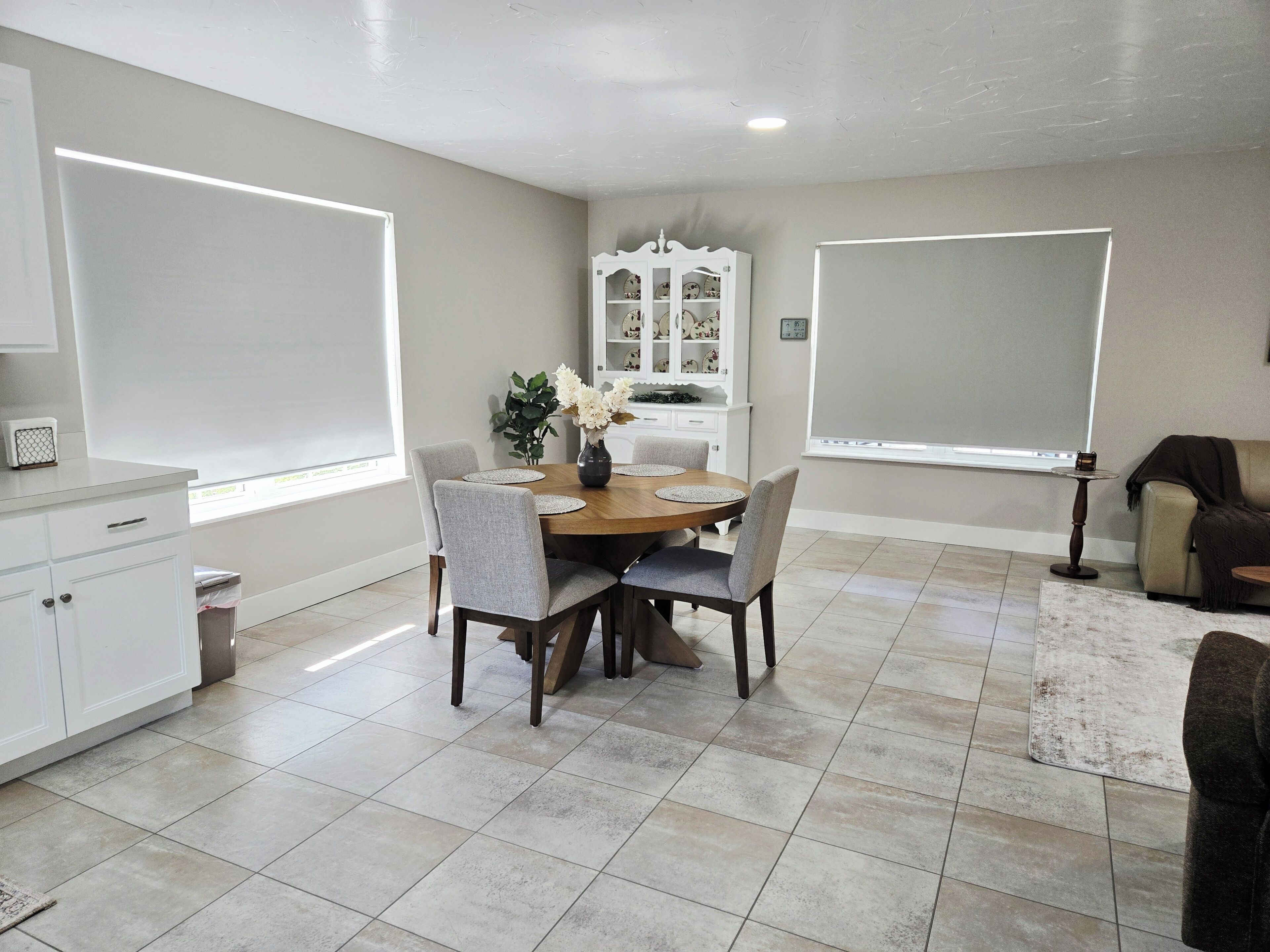 A dining area with a round table, chairs, and a cabinet.