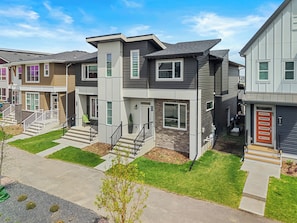 A modern apartment building with multiple units, each featuring a front porch, a staircase, and a door. - Sunlit Slate, 3BR+Bonus+XBOX+BBQ with Modern Design + Private Deck (Calgary)