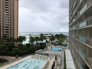 Ein Hotel mit Poolbereich, Blick auf den Strand und einem Hochhaus.