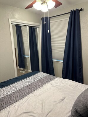 A bedroom with a bed, a ceiling fan, and a window with curtains. - Comfortable Olathe Getaway  3 Bedrooms - Sleeps 6 (Olathe)