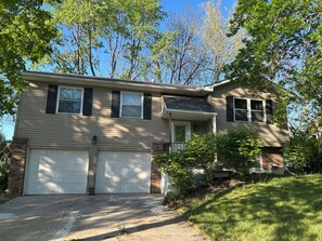 A two-story house with a garage, a front porch, and a brick foundation. - Comfortable Olathe Getaway  3 Bedrooms - Sleeps 6 (Olathe)