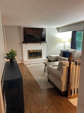 A living room with a fireplace, a sofa, a TV, and a plant. - Comfortable Olathe Getaway  3 Bedrooms - Sleeps 6 (Olathe)