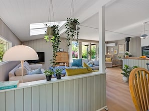 Ein modernes Wohnzimmer mit einer Couch, einem Couchtisch und hängenden Pflanzen.