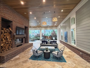 A spacious patio with a brick fireplace, outdoor seating, and a view of the surrounding area. - Families favorite Luxury Suites + Saltwater Pool+Gym + Free Parking+Ev Charging (Matthews)