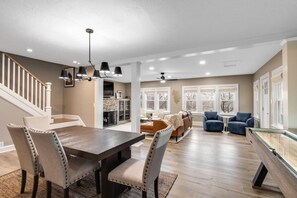 A spacious living area with a dining table, sofas, and a pool table. - Riverside Retreat Vacation Home (West Lafayette)