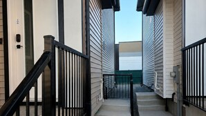 Un corridoio con una porta, una scala e una ringhiera.