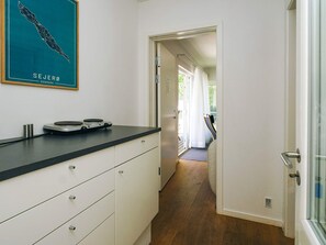 A kitchen with a black countertop, white cabinets, and a map of Sejerø, Denmark on the wall.