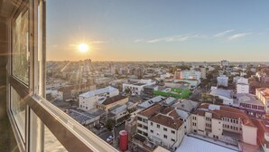 En stadsbild med byggnader, en klar himmel och en sol som går upp eller ner.