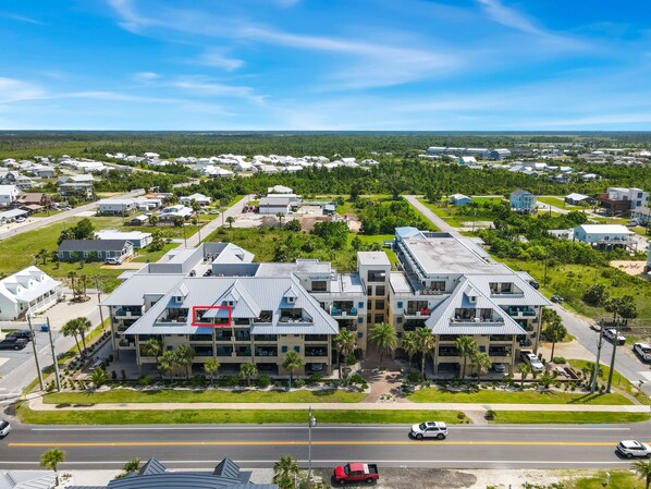 Vista aérea de una zona residencial con varios edificios, calles y zonas verdes.