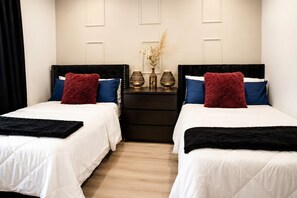 A hotel room with two beds, a nightstand, and a dresser. -  Houston Heights 3 Beds + Garage (Houston)