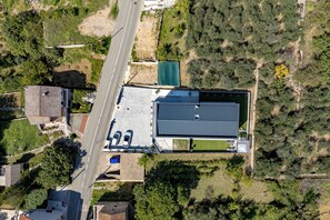 Ein Luftbild eines Gebäudes mit flachem Dach, angrenzendem Parkplatz und umliegender Bepflanzung.