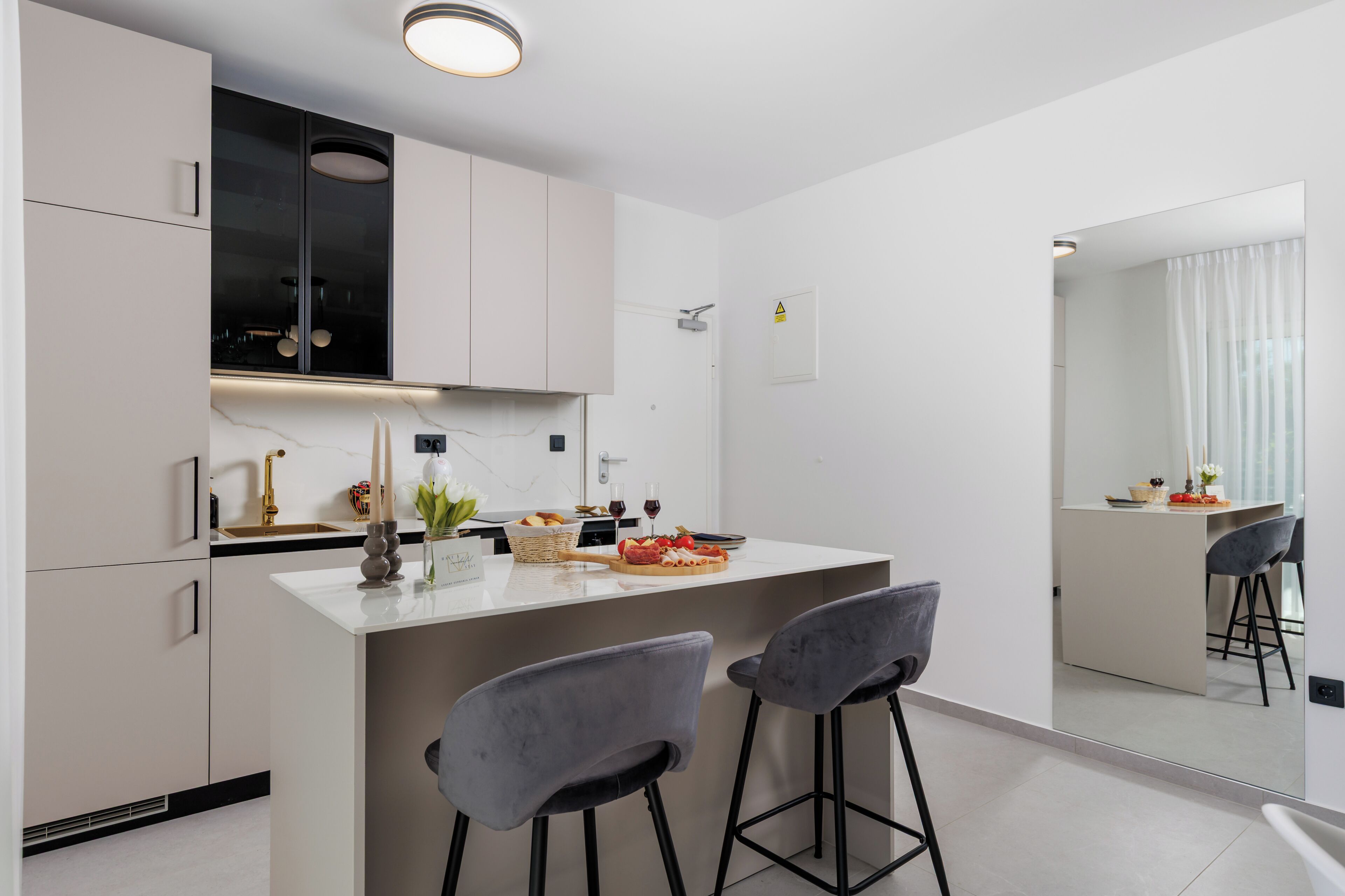 Una cocina moderna con una isla central, taburetes de bar y una zona de comedor con vistas.
