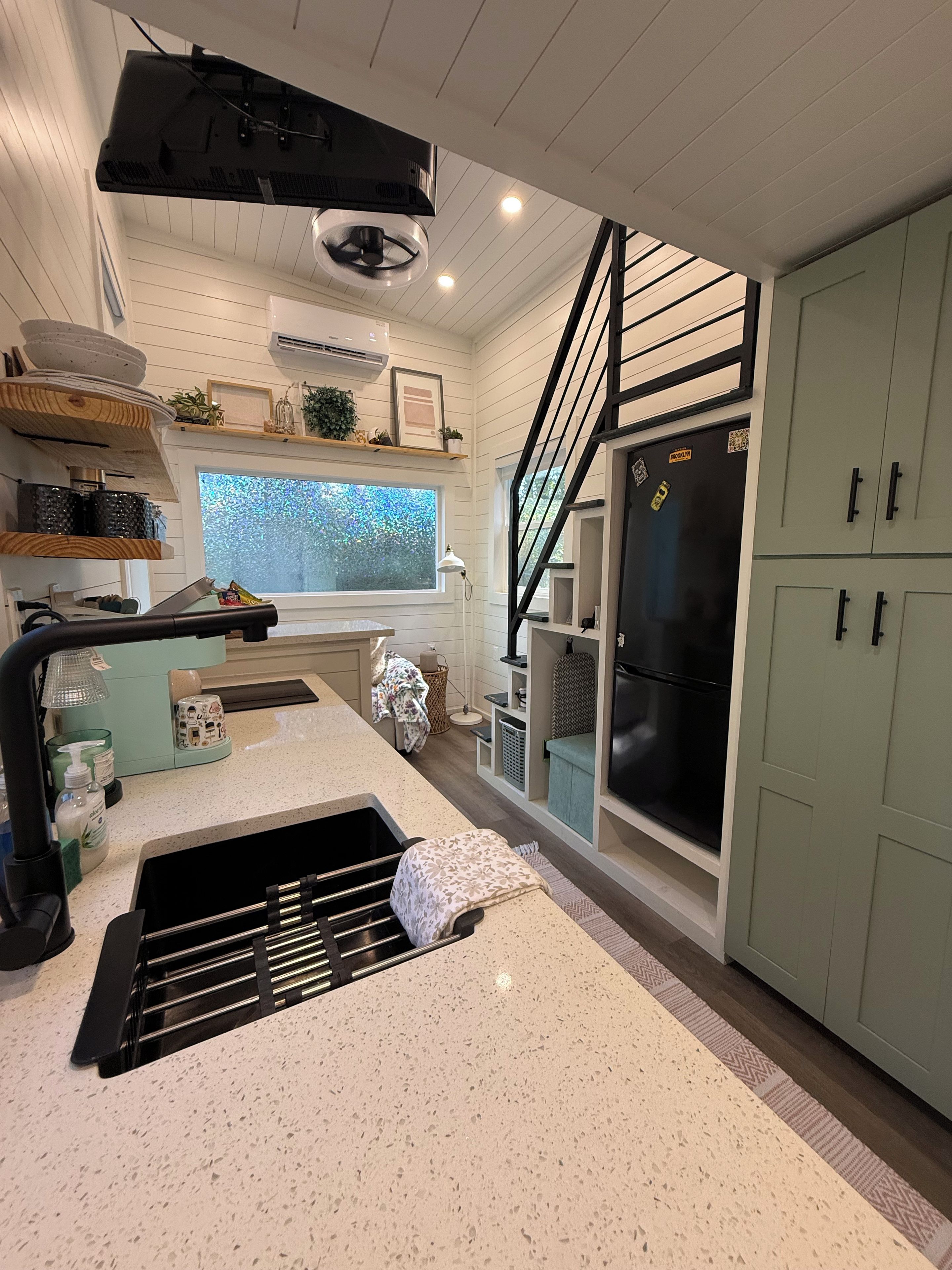 A modern kitchen with a central island, a built-in stove, and a refrigerator.