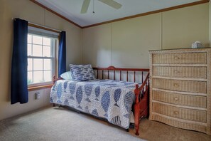 A bedroom with a single bed, a dresser, a window with curtains, and a ceiling fan. - The Hoagie House - Family-Friendly Canal Home with Private Dock (Frankford)