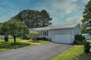 A single-story residential house with a front garage, a driveway, and a well-maintained lawn. - The Hoagie House - Family-Friendly Canal Home with Private Dock (Frankford)