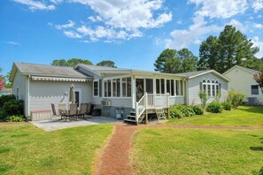 A single-story house with a covered patio, a front door, and a small front yard.