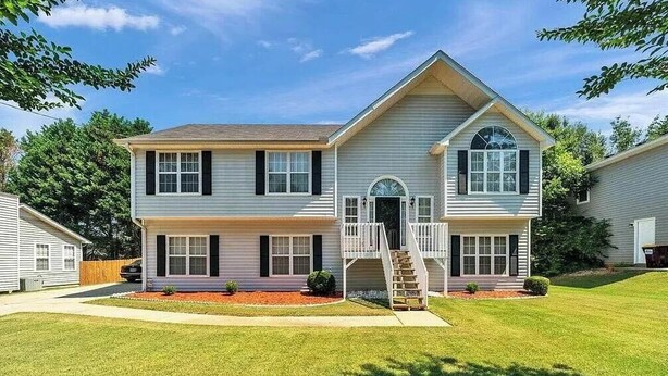 A two-story house with a front porch, a staircase, and a small front yard. - Newly Renovated Guest Floor (Mableton)