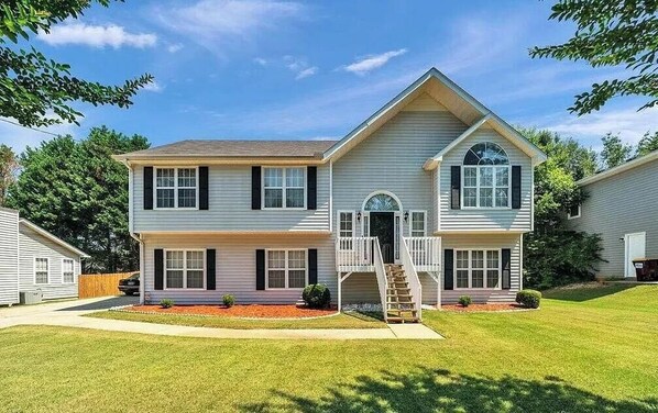 A two-story house with a front porch, a staircase, and a small front yard.