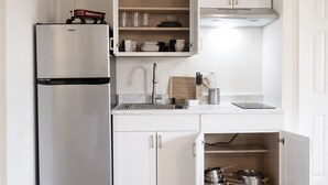 A kitchen with a stainless steel refrigerator, a wooden cutting board, and a sink. - Newly Renovated Guest Floor (Mableton)