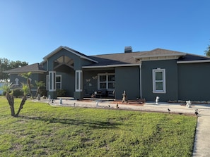 A two-story house with a covered porch, a garage, and a well-maintained lawn. - Cul-de-Sac Home – 1.28 acres – Tampa & Brandon (Dover)