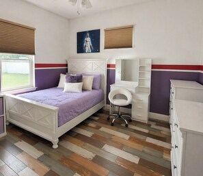 A bedroom with a bed, a desk, a chair, and a dresser. - Cul-de-Sac Home – 1.28 acres – Tampa & Brandon (Dover)
