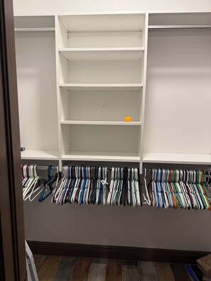 A closet with multiple shelves and a rack of hanging clothes. - Cul-de-Sac Home – 1.28 acres – Tampa & Brandon (Dover)