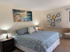 A bedroom with a bed, a nightstand, a lamp, a chair, a painting, and a wall with abstract art. - Amazing Views, Family-Friendly 3 Bdrm Boulder Townhome Open Space, 10mns Dntown! (Boulder)